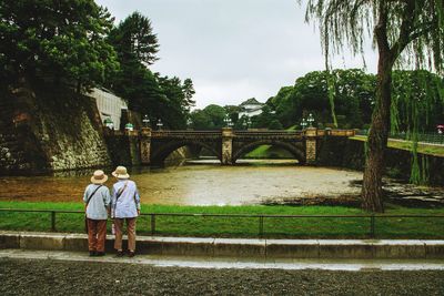 Rear view of people on bridge over river