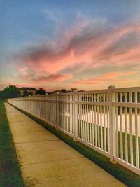 Walkway against sky during sunset