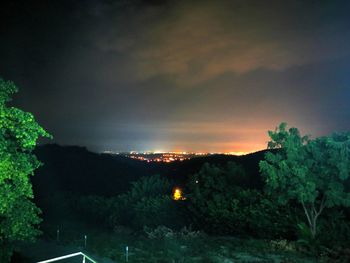 Illuminated city against sky at night