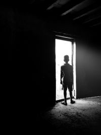 Rear view of boy standing by door