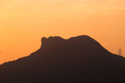 Scenic view of silhouette mountains against orange sky