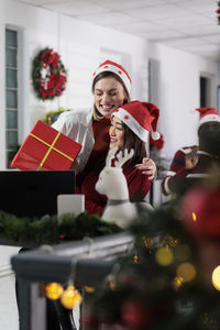 Portrait of young woman holding christmas tree