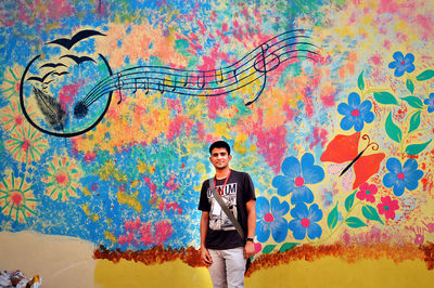 Portrait of young man standing on wall