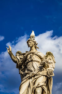 Low angle view of statue against blue sky