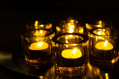 Close-up of illuminated tea light candles on table