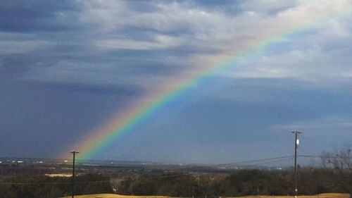 Rainbow over landscape against sky