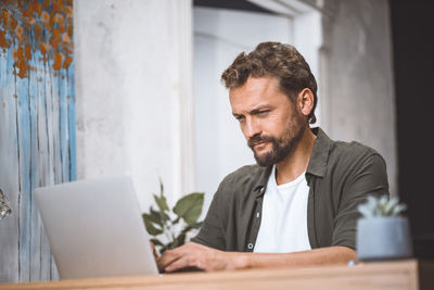 Young man using laptop at table