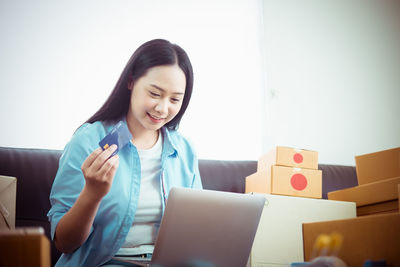 Portrait of a smiling young woman using mobile phone