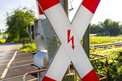 Guarded railroad crossing in the countryside with open barriers and cross of saint andrew.