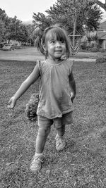 Portrait of cute girl standing on field