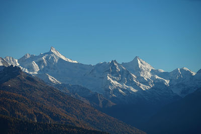 Scenic view of snowcapped mountains against clear blue sky