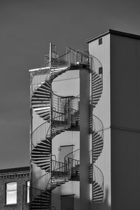 Low angle view of spiral staircase by building against sky