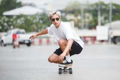 Portrait of man crouching on skateboard