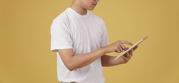 Midsection of man using mobile phone