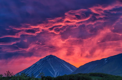 Scenic view of mountain against cloudy sky during sunset