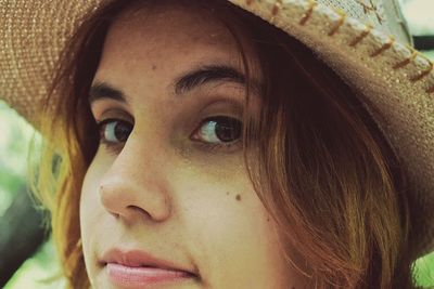 Close-up portrait of young woman wearing hat