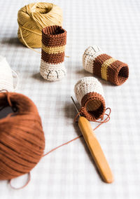 High angle view of crochet hook with thread and products on table