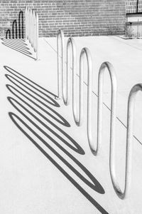 Modern urban bike rack and shadows cast on concrete surface. black and white version