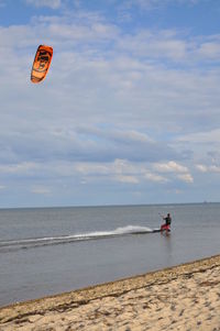 People on beach by sea against sky