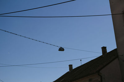 Low angle view of birds flying against clear sky