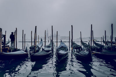 Sailboats moored in sea against sky