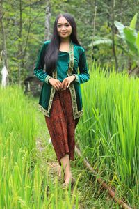 Portrait of young woman standing on field
