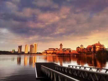 Buildings at waterfront during sunset