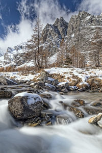 Snow covered rocks against sky