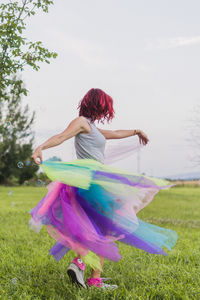 Woman dancing on field against trees