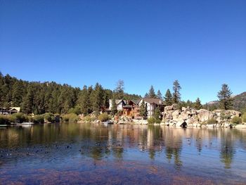 Calm lake against clear blue sky