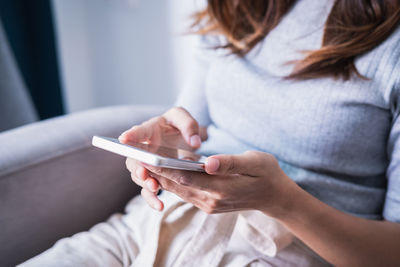 Midsection of woman using mobile phone