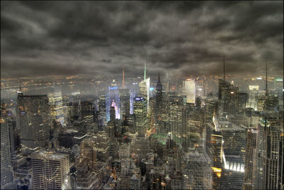 Illuminated cityscape against sky at night