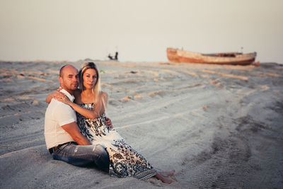 Happy young couple enjoying on a sandy beach at sunset.