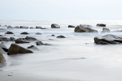 Rocks in sea against sky
