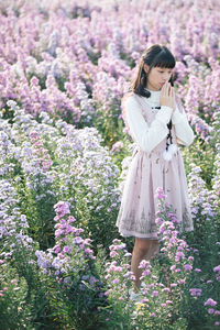 Woman standing on purple flowering plants