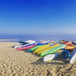 Multi colored umbrellas on beach against clear blue sky