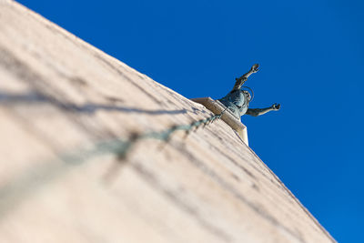 Low angle view of statue against clear blue sky