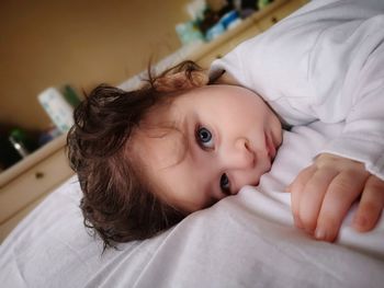 Portrait of cute baby lying on bed at home