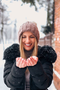 Portrait of smiling young woman in snow