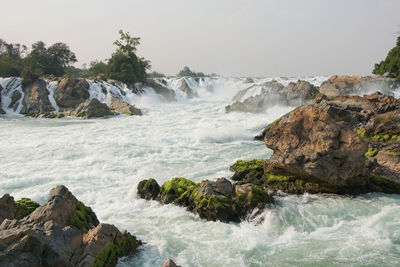 Scenic view of waterfall against sky