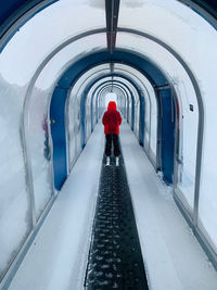 Rear view of man walking in tunnel