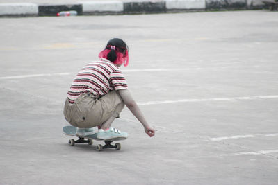 Rear view of girl riding motorcycle on road