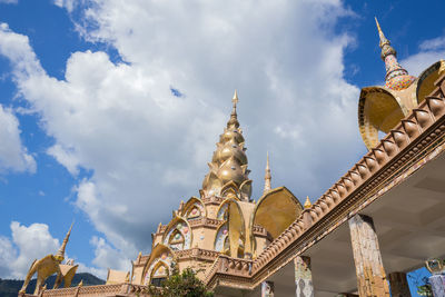 Low angle view of buildings against cloudy sky