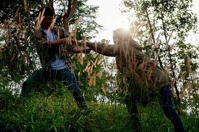 Children playing on grass against trees