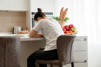 Woman sitting on table at home