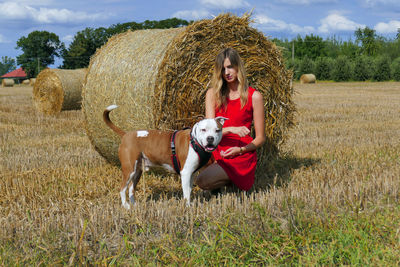 Portrait of young woman with horse standing on field