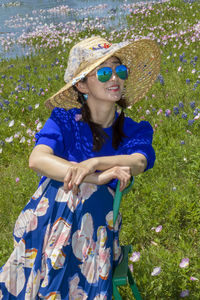 Young woman wearing sunglasses and red flower plants