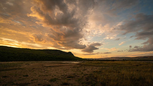 Scenic view of land against sky during sunset