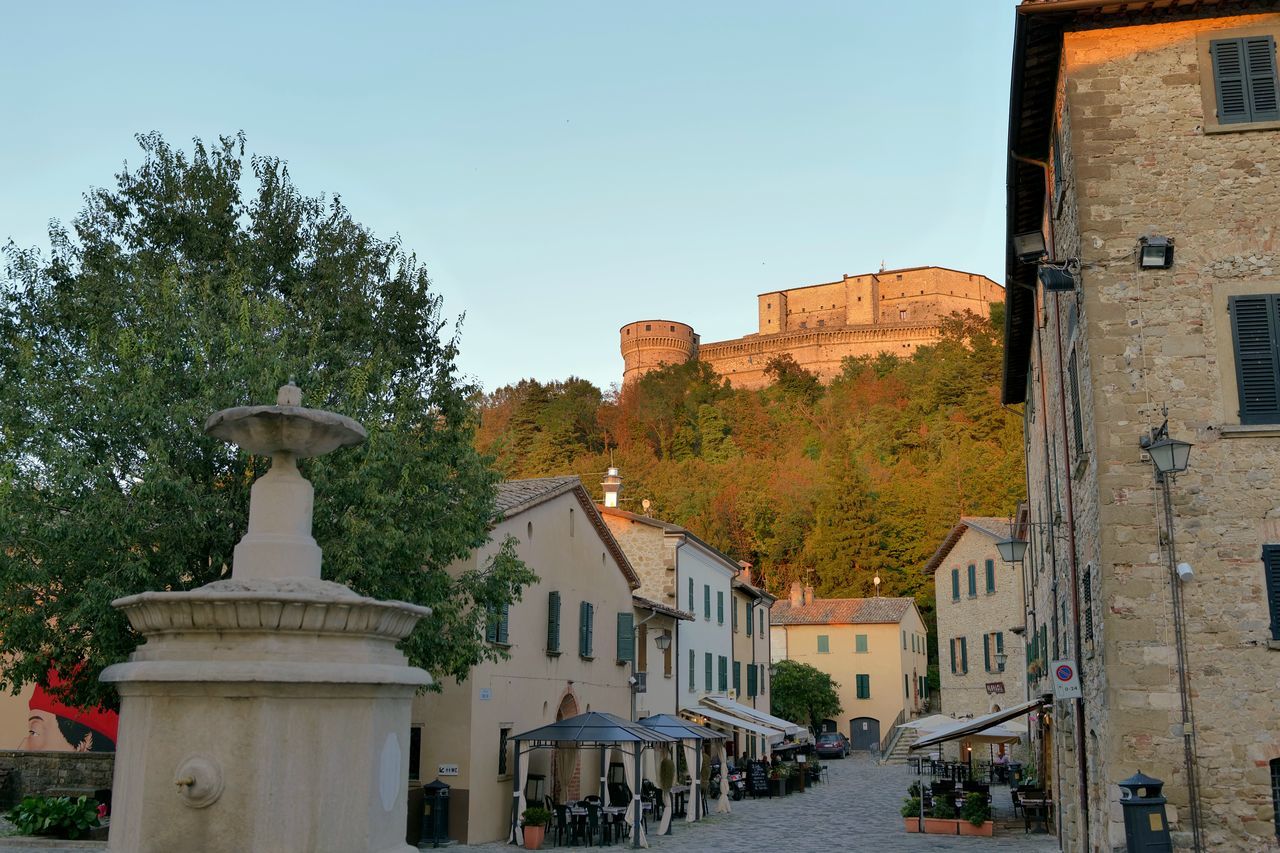 architecture, town, building exterior, built structure, building, city, sky, nature, neighbourhood, tree, travel destinations, history, plant, the past, street, travel, residential district, clear sky, tourism, house, no people, outdoors, village, day, blue, transportation, old