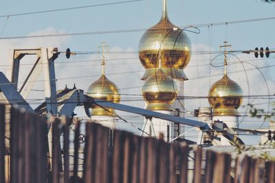 Golden domes of church seen through cables